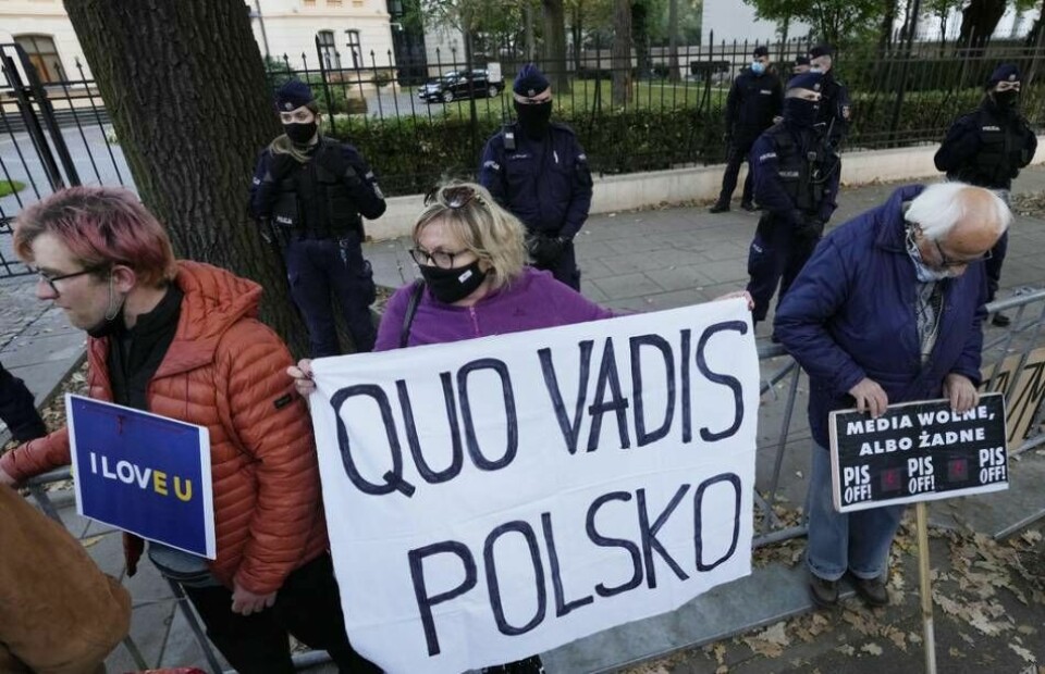 ”Vart går du Polen?” står det på det tygstycke som hölls upp av en kvinna vid en demonstration utanför Polens författningsdomstol i Warszawa i torsdags. Domstolen slog fast att landets lagar står över EU:s. Foto: Czarek Sokolowski/AP Photo/TT