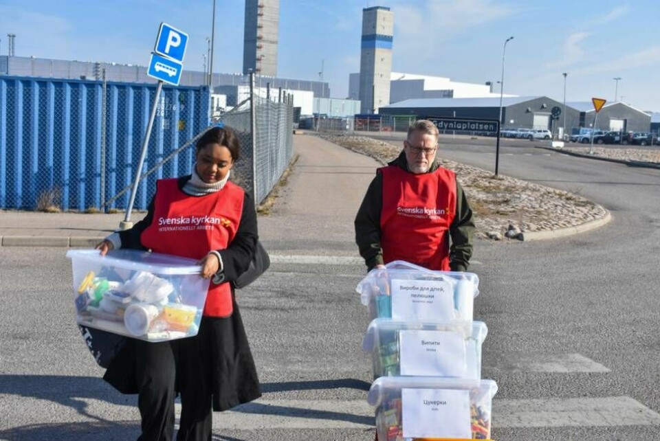 Batsieba Tedros och Göran Olsson kånkar på lådor med förnödenheter till ankommande flyktingar. Foto: Ola Karlman