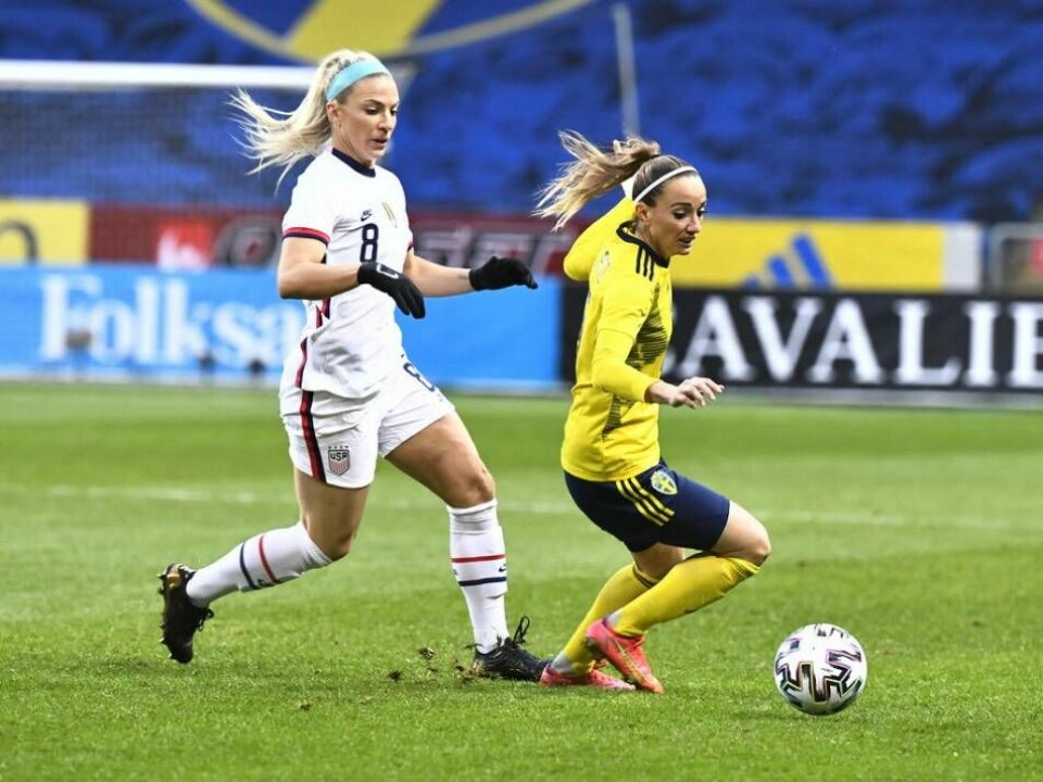 USA:s Julie Ertz, i vitt, kämpar mot Sveriges Kosovare Asllani i en landskamp på Friends Arena i april 2021. Foto: Claudio Bresciani/TT