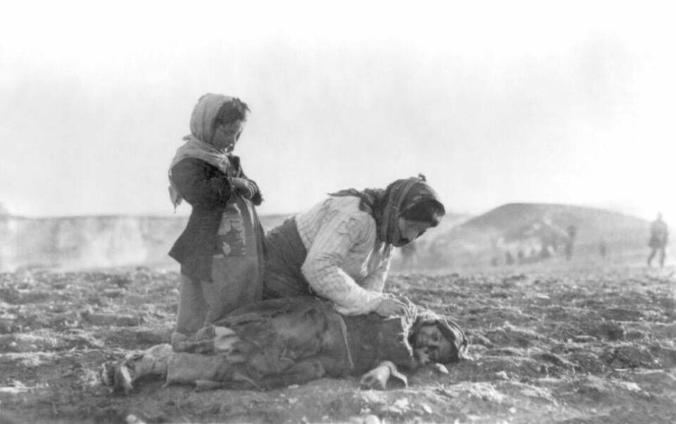 En armenisk kvinna knäböjer vid sidan av en död flicka i Aleppo. Foto: Wikimedia Commons