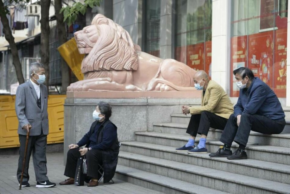 Exakt hur covid-19 började spridas i Wuhan är oklart. På bilden ses Wuhanbor i munskydd utanför en bank i staden.