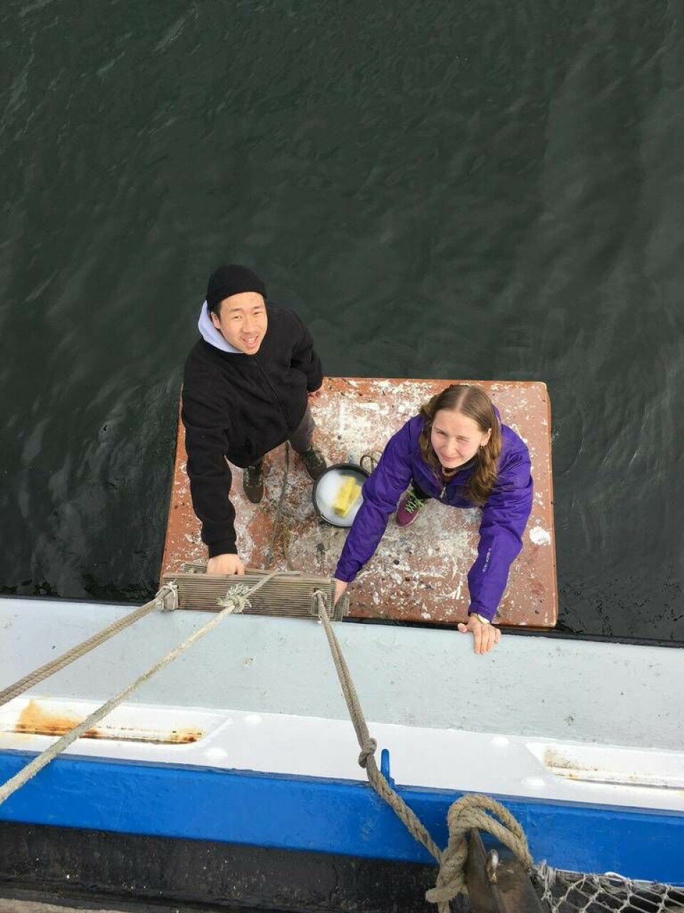 Johan Nilsson och Klara Pettersson rengör utsidan av båten under förberedelserna för resan. Foto: Privat