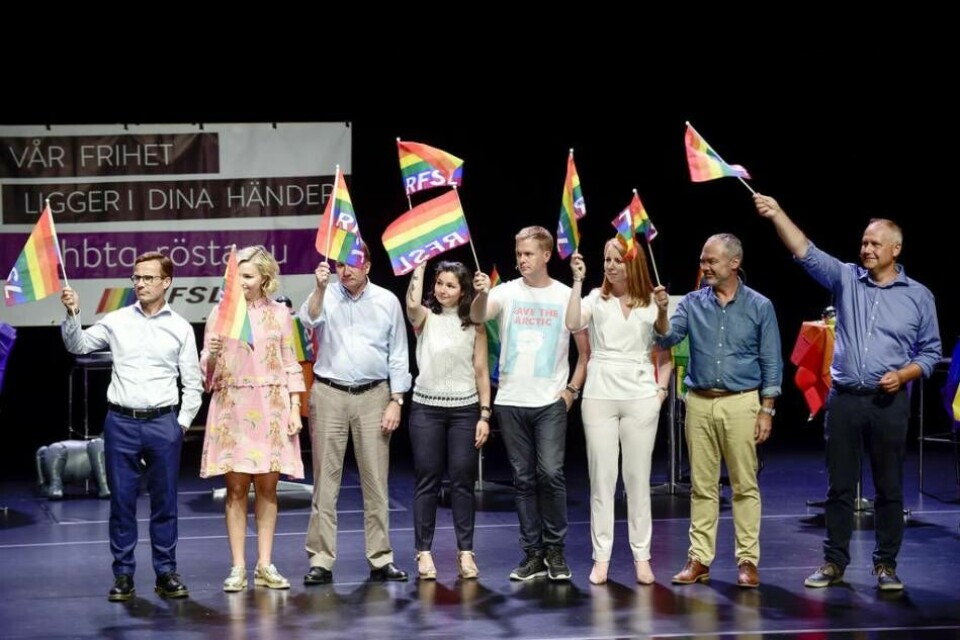 Med varierande entusiasm höll alla partiledarna vid Pride-debatten upp sina flaggor för att stämma in i påståendet att 'SD är ett homofobiskt parti som vi inte kommer att samarbeta med'. Foto: Hossein Salmanzadeh / TT