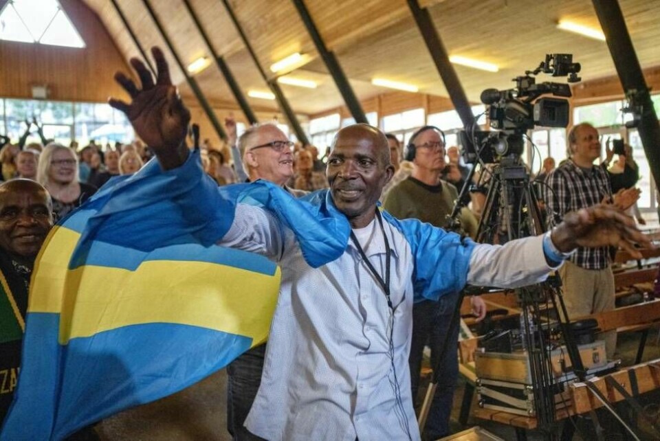 En tanzanisk bönekrigare insvept i den svenska flaggan bad för Sverige på bönekonferensen i Ralingsås i augusti.