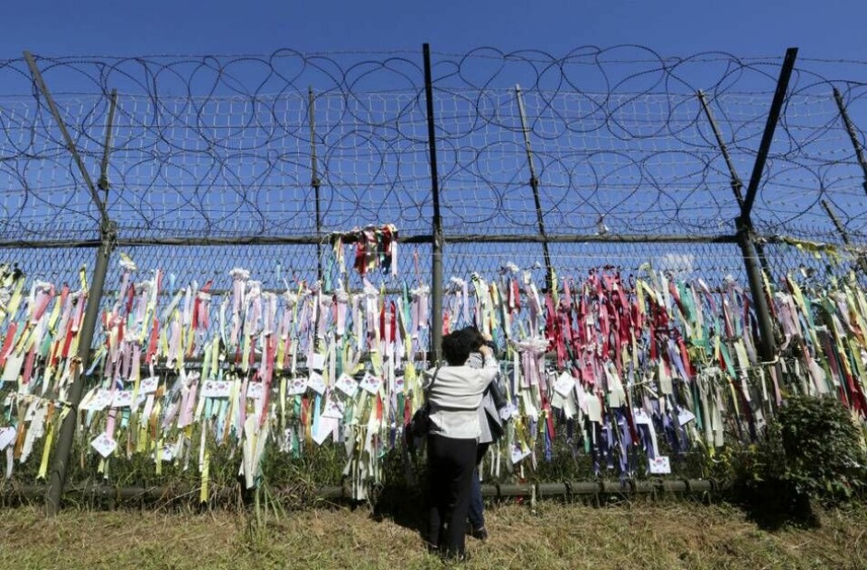Nordkoreanska avhoppare i Sydkorea gråter framför ett taggtrådsstängsel dekorerat med hoppfulla meddelanden om en återförening av de båda länderna på Koreahalvön. Foto: Ahn Young-joon/AP/TT