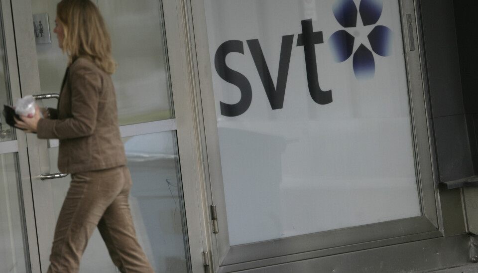 En kvinna går in i entrén till SVT i Stockholm.