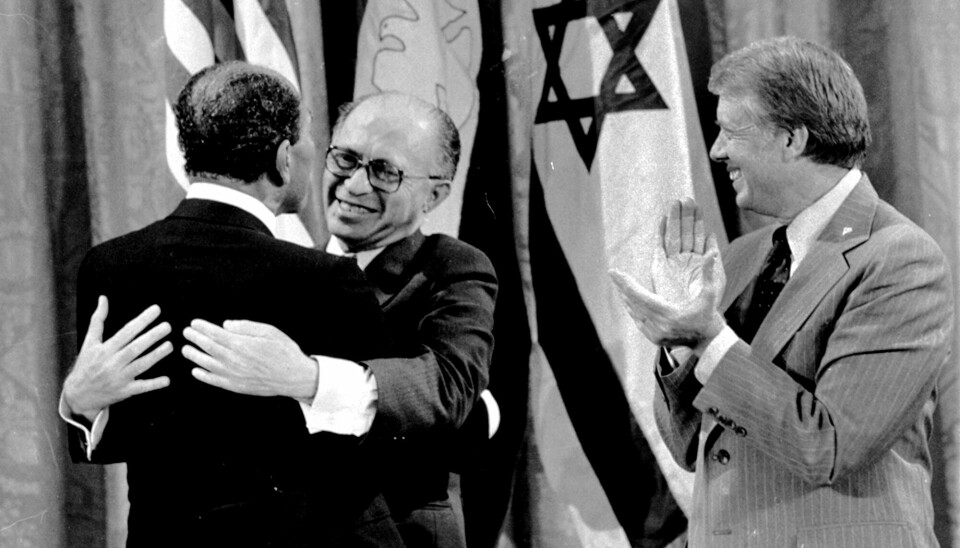 Egyptiske presidenten Anwar Sadat (t v) och Israels premiärminister Menachem Begin omfamnar varandra bredvid president Jimmy Carter vid tillkännagivandet av fredsavtalet i september 1978. En bedrift som Sadat och Begin senare skulle få ta emot Nobels fredspris för.