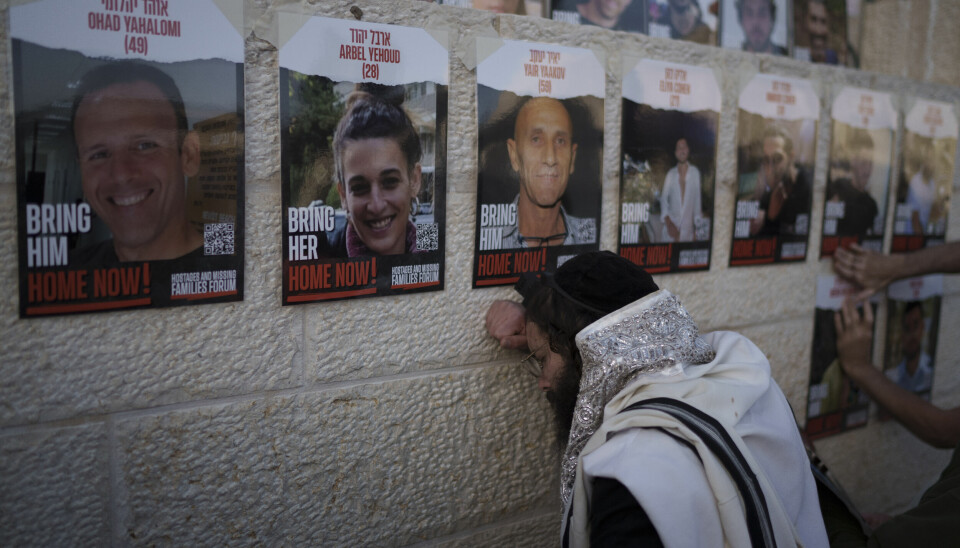 En judisk man står framför bilder på gisslan vid västra muren i Jerusalem.