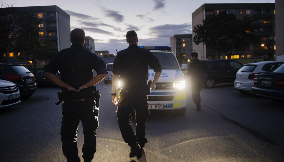 Poliser vid en polisbil i Rinkeby.