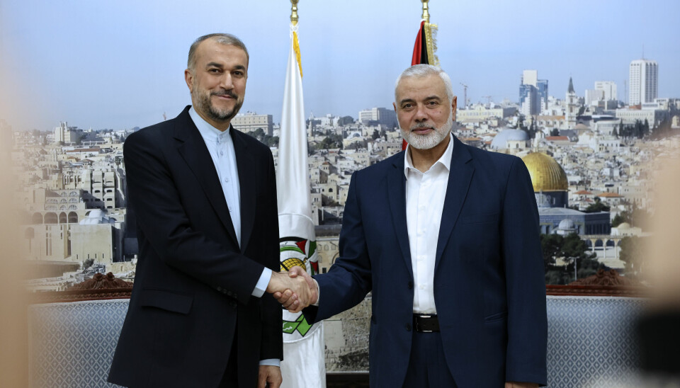 In this picture released by the Iranian Foreign Ministry on Wednesday, Dec. 20, 2023, Iran's Irans foreign Minister Hossein Amirabdollahian, left, shakes hands with Hamas chief Ismail Haniyeh, right, during their meeting in Doha, Qatar. (Iranian Foreign Ministry via AP) VAH101