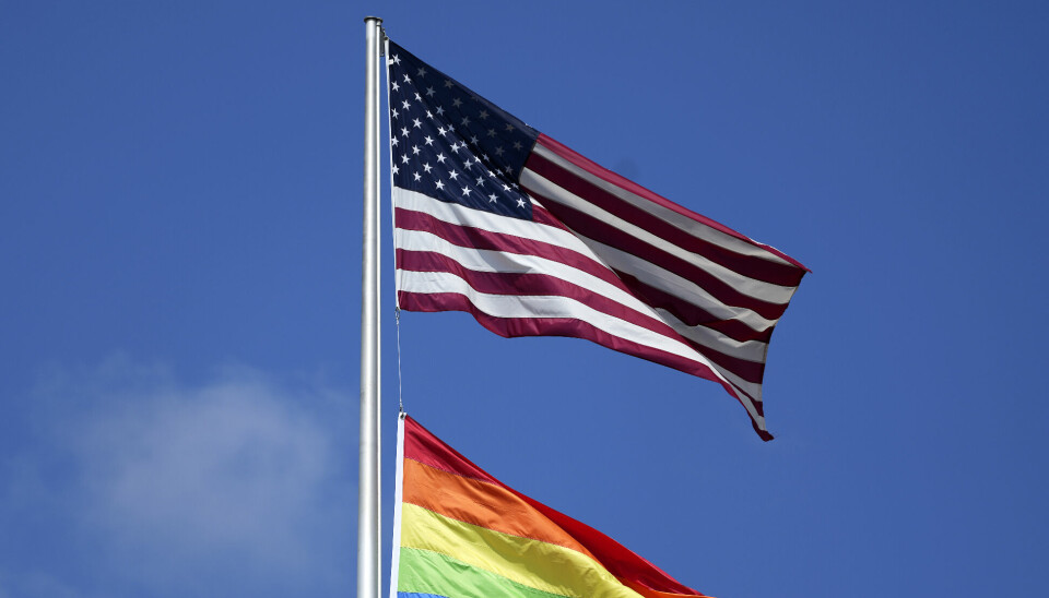 The flag of the United States of America, top, and a Rainbow Color Flag, bottom, wave on top of the US embassy in Berlin, Germany, Saturday, July 10, 2021. (AP Photo/Michael Sohn) SOB107