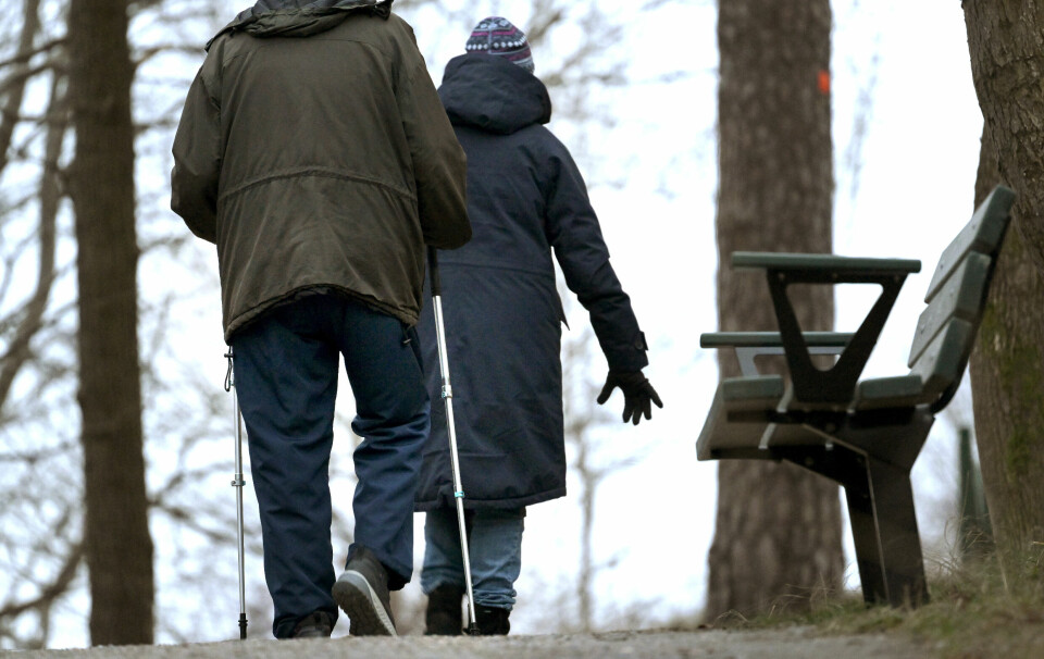 Äldre par på promenad på gångväg med gåstavar