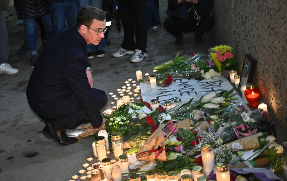 Statminister Ulf Kristersson på minnesplats med blommor och ljus