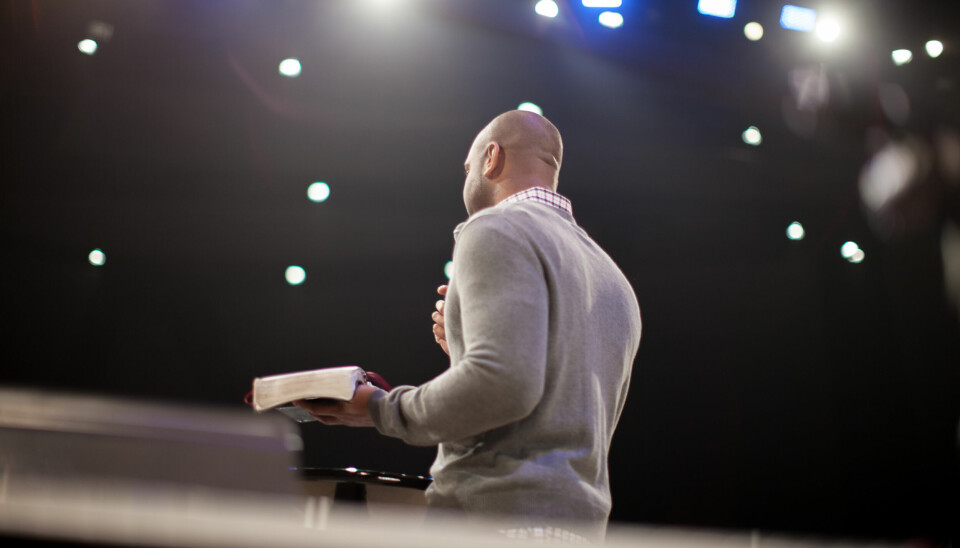 En man predikar med en bibel i sin hand.