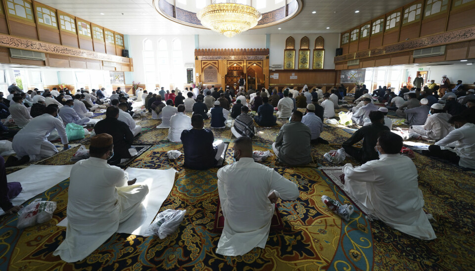 People sit with social distancing inside Manchester Central Mosque, in Manchester, northern England, after having their temperatures checked at the entrance to try stop the spread of coronavirus, as Muslims worldwide mark the start of the Eid al-Adha holiday, Friday, July 31, 2020. The British government on Thursday night announced new rules on gatherings in some parts of Northern England, including Manchester, that people there should not mix with other households in private homes or gardens in response to an increase trend in the number of cases of coronavirus cases per 100,000 people. (AP Photo/Jon Super) LMD118