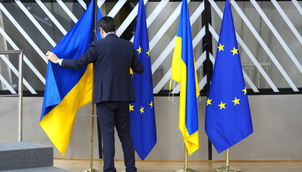 A member of protocol arranges the Ukrainian and EU flags during an EU summit at the European Council building in Brussels on Thursday, Feb. 9, 2023. European Union leaders are meeting for an EU summit to discuss Ukraine and migration. (AP Photo/Virginia Mayo) VLM141