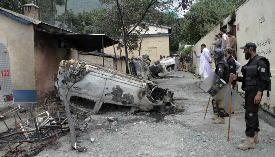 Police officers examine burnt vehicles which were torched by a Muslim mob in an attack, in Madyan in Pakistan's Khyber Pakhtunkhwa province, Friday, June 21, 2024. A Muslim mob in northwestern Pakistan broke into a police station, snatched a man who was held there and then lynched him over allegations that he had desecrated Islam's holy book, the Quran. (AP Photo/Naveed Ali) ISL106