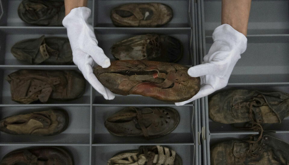 A worker rubs away dust on a shoe that belonged to a child victim of the former Nazi German death camp Auschwitz-Birkenau at the conservation laboratory on the grounds of the camp in Oswiecim, Poland, Wednesday, May 10, 2023. (AP Photo/Michal Dyjuk) DYJ511