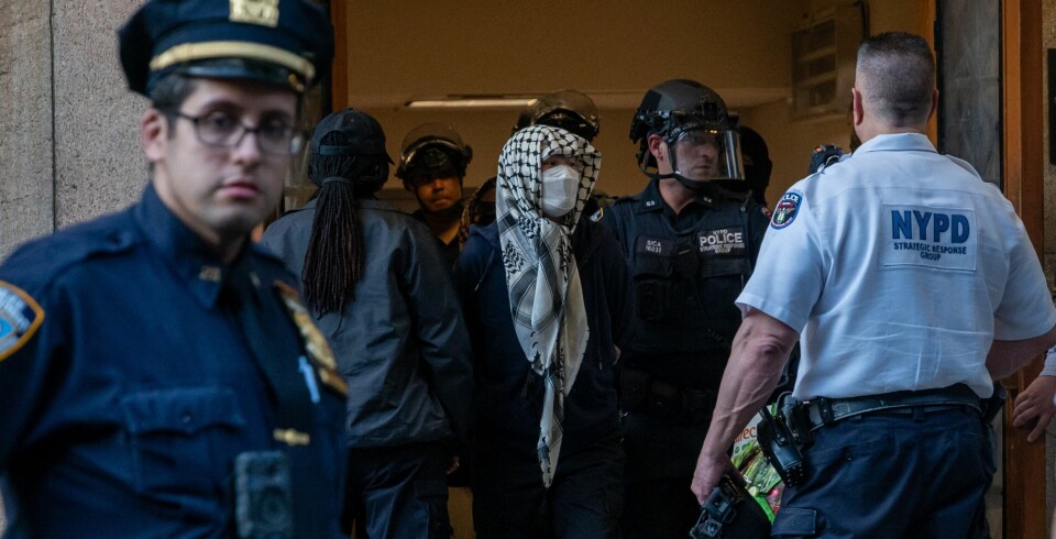 Ett stort antal personer greps och fördes ut ur skolans lokaler när polisen tvingades ingripa. NEW YORK, NEW YORK - MAY 07: Pro-Palestinian protesters are escorted out of Columbia University's Butler Library after their arrest for occupying the library space on May 07, 2025 in New York City. Crowds of protesters grew as a standoff with security at the library continued into the evening. Spencer Platt/Getty Images/AFP (Photo by SPENCER PLATT / GETTY IMAGES NORTH AMERICA / Getty Images via AFP)