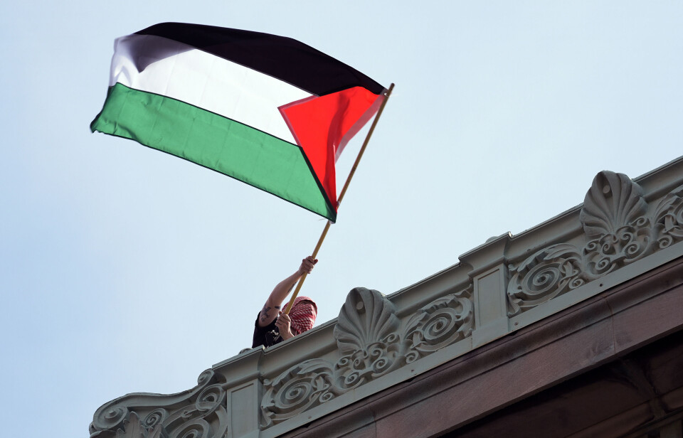 Columbia university har även tidigare varit utsatta för propalestinska protester, som här i april förra året. A student protester waves a Palestinian flag above Hamilton Hall on the campus of Columbia University, Tuesday, April 30, 2024, in New York. Early Tuesday, dozens of protesters took over Hamilton Hall, locking arms and carrying furniture and metal barricades to the building. Columbia responded by restricting access to campus. (Pool Photo/Mary Altaffer) NYJJ262