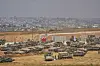 Israeli soldiers work on tanks and APCs at a staging area near the border with the Gaza Strip, in southern Israel, Thursday, May 15, 2025. (AP Photo/Ariel Schalit) OZW106