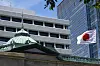 FILE - A Japanese flag flutters at the Bank of Japan headquarters in Tokyo, July 29, 2022. The Bank of Japan raised its key interest rate Wednesday, July 31, 2024, to .25% from 0.1%, acting to curb the yen’s slide against the U.S. dollar. (AP Photo/Shuji Kajiyama, File) TKHK301