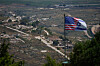 Israeli and U.S. flags stand against a backdrop of destroyed buildings in southern Lebanon, as seen from northern Israel, Sunday, June 21, 2026. (AP Photo/Ohad Zwigenberg) XOB109