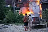 People watch as building burns after a Russian missile attack in Kyiv, Ukraine, Sunday, May 24, 2026. (AP Photo/Efrem Lukatsky) XSG105