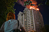 A woman looks at an apartment building burning after a Russian missile attack in Kyiv, Ukraine, Thursday, July 2, 2026. (AP Photo/Danylo Antoniuk) XEL101