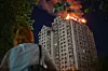A woman looks at an apartment building burning after a Russian missile attack in Kyiv, Ukraine, Thursday, July 2, 2026. (AP Photo/Danylo Antoniuk) XEL101