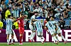 Argentina-spelare i blå- och vitrandiga tröjor firar ett mål framför jublande publik.
