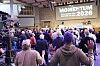 Deltagare med lyfta händer på Momentum-konferensen för män framför en scen med en stor skärm.