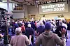 Deltagare med lyfta händer på Momentum-konferensen för män framför en scen med en stor skärm.