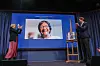 Kjersti Fløgstad och Jørgen Watne Frydnes applåderar Navi Pillay på en skärm på Nobels Fredscenter.