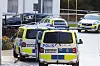 Flera polisfordon och avspärrningsband på en gata i södra Stockholm efter en skottlossning vid en personbil.