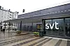 SVT:s logotyp på en glasfasad vid entrén till Sveriges Television i Stockholm.