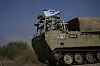 Israeliska soldater i ett militärfordon med den israeliska flaggan rör sig mot Gazaremsans gräns.