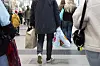 Personer sedda bakifrån som bär på kassar under julhandeln i köpcentret Nordstan i Göteborg.